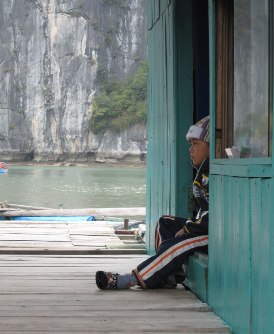 Dreng fra flydende landsby i Halong Bay